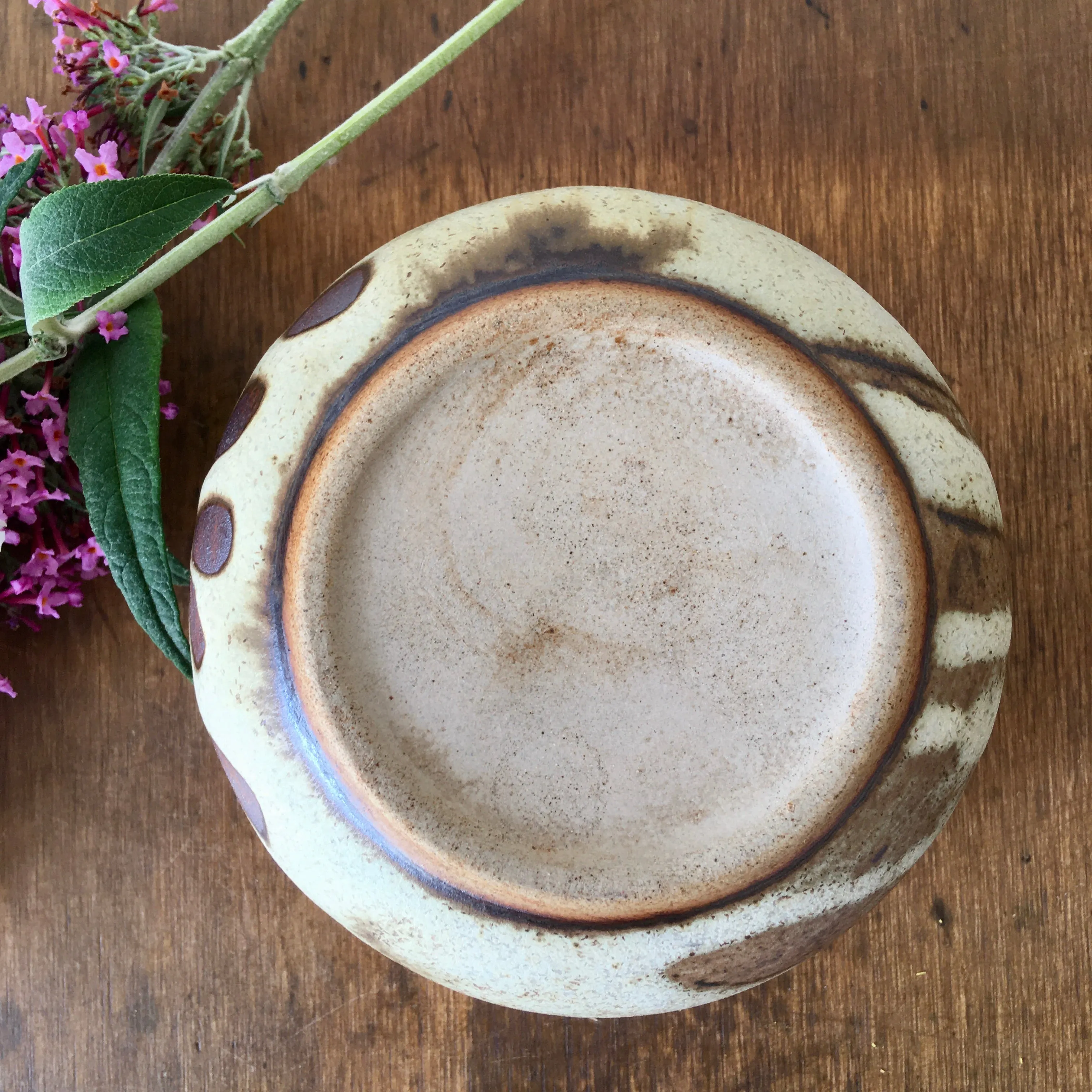 A hand-thrown stoneware studio pottery bowl with floral decoration