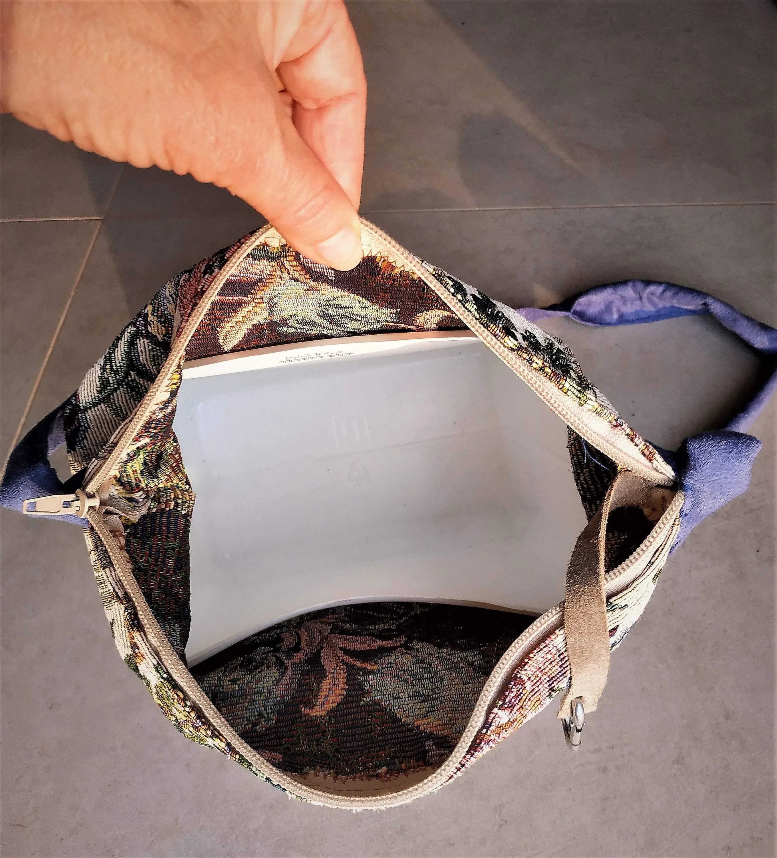 Bags made of tapestry with a long blue-gray handle and a zipper